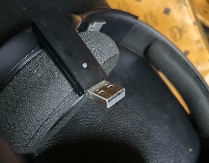 Headphones with a broken USB connector showing damage from people borrowing and mishandling items.