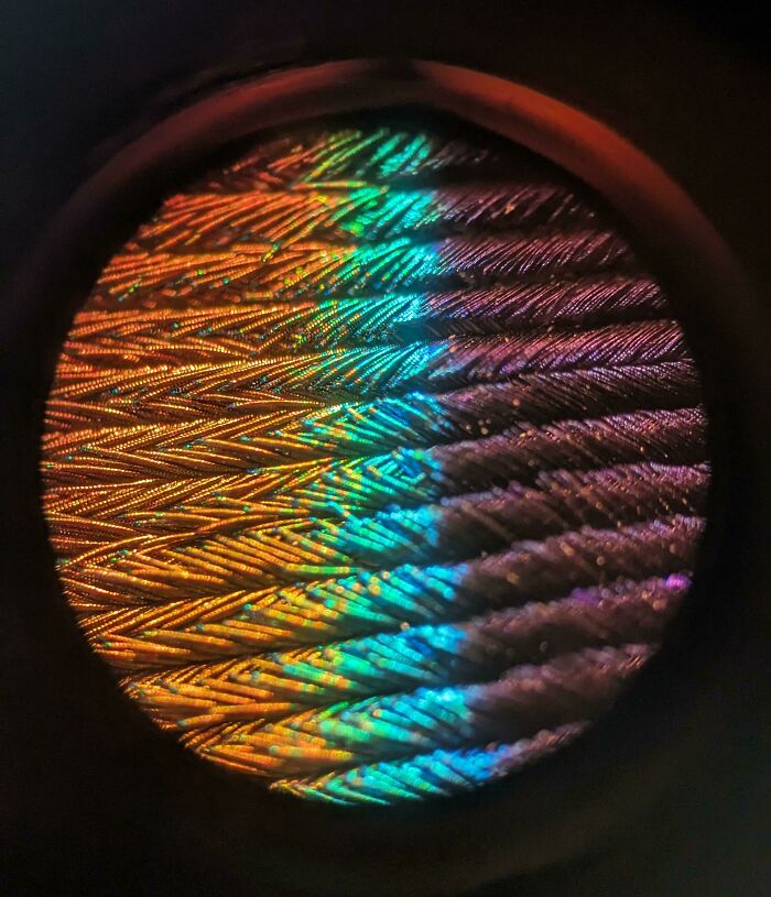 Microscopic image showing colorful, intricate patterns on an ordinary object under high magnification.