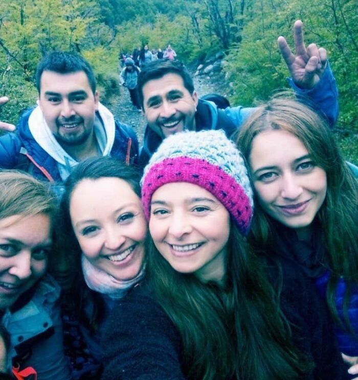 Group of friends hiking outdoors, smiling together on a trail, capturing a moment before chilling ghost encounters.