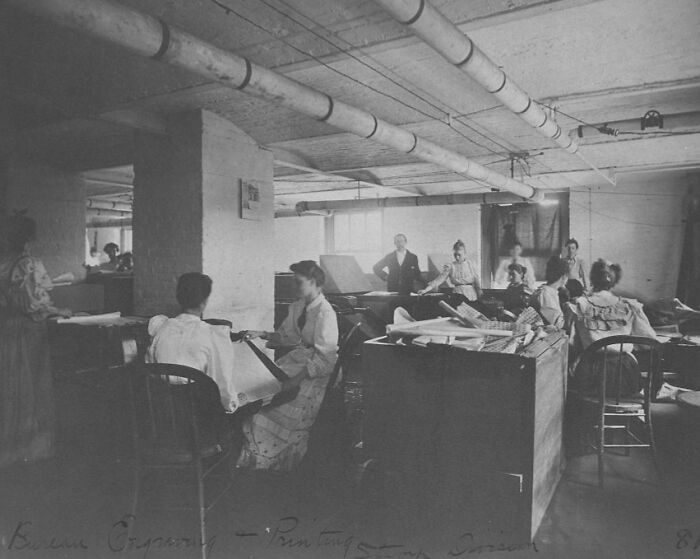 Vintage photo of American working class women in a printing office, focused on their jobs and tasks.
