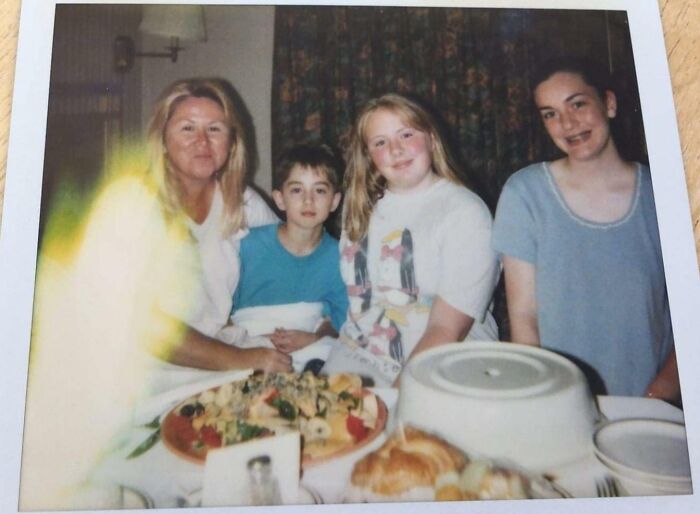 Family gathered around a table with food, featuring a chilling ghost encounter with a glowing apparition on the left side.