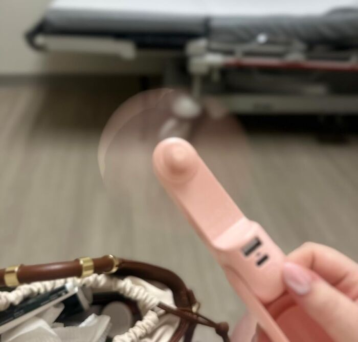 Portable handheld fan in a hand, ideal for staying cool during International Picnic Day outdoor feasts.