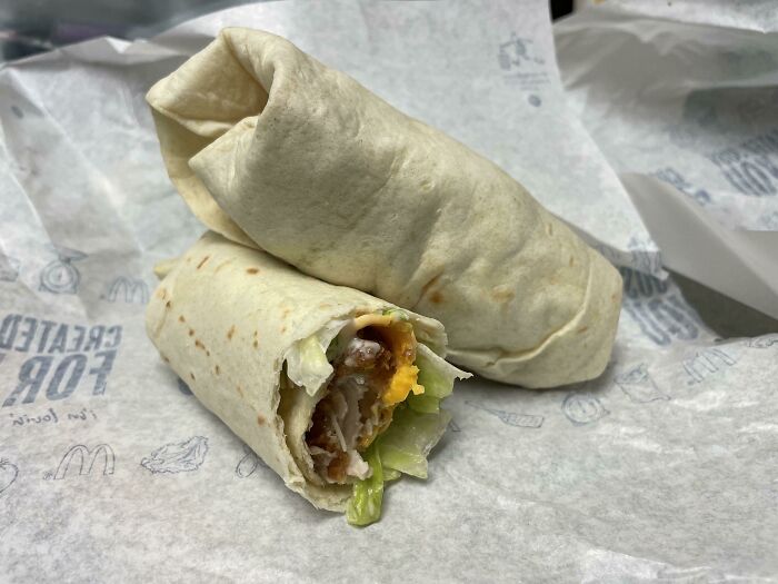 Two wrapped burritos on branded paper, showing lettuce, cheese, and sauce, representing beloved foods that disappeared.
