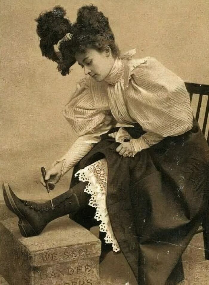 Victorian times woman adjusting her boot laces while seated, showcasing fashion from strange moments in Victorian times.