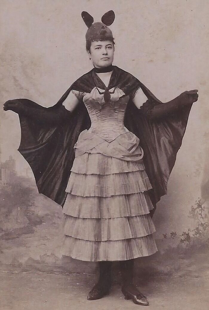Victorian woman wearing a bat costume with wings outstretched, showcasing strange moments from Victorian times.
