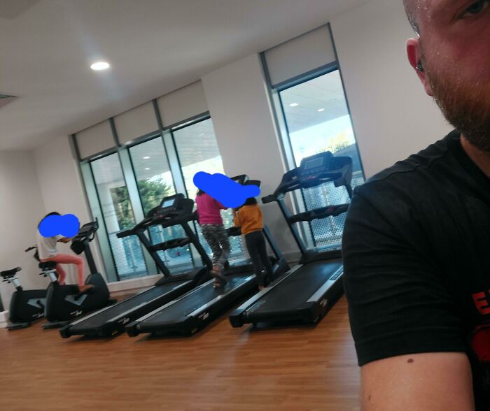 Gym interior with people using treadmills and exercise bikes, illustrating annoying gym moments during busy hours.