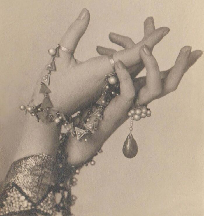 Vintage photo of hands adorned with intricate jewelry, capturing a mesmerizing moment rich in historical detail.