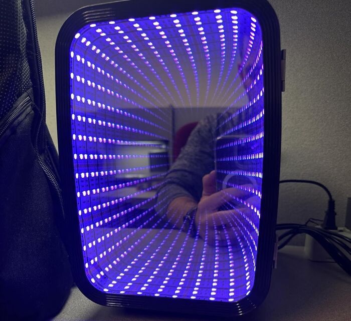 LED kitchen gadget displaying infinite light effect with blue dots inside a black frame on a countertop surface.