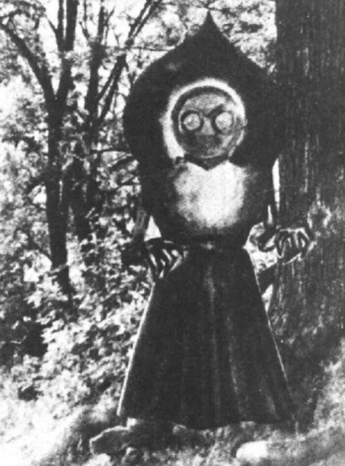 Black and white eerie figure with a distorted face in a forest, illustrating scary and unsettling Wikipedia articles.