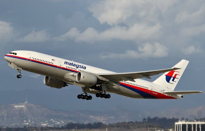 Malaysia Airlines plane taking off against cloudy sky, illustrating unsettling and scary Wikipedia articles.