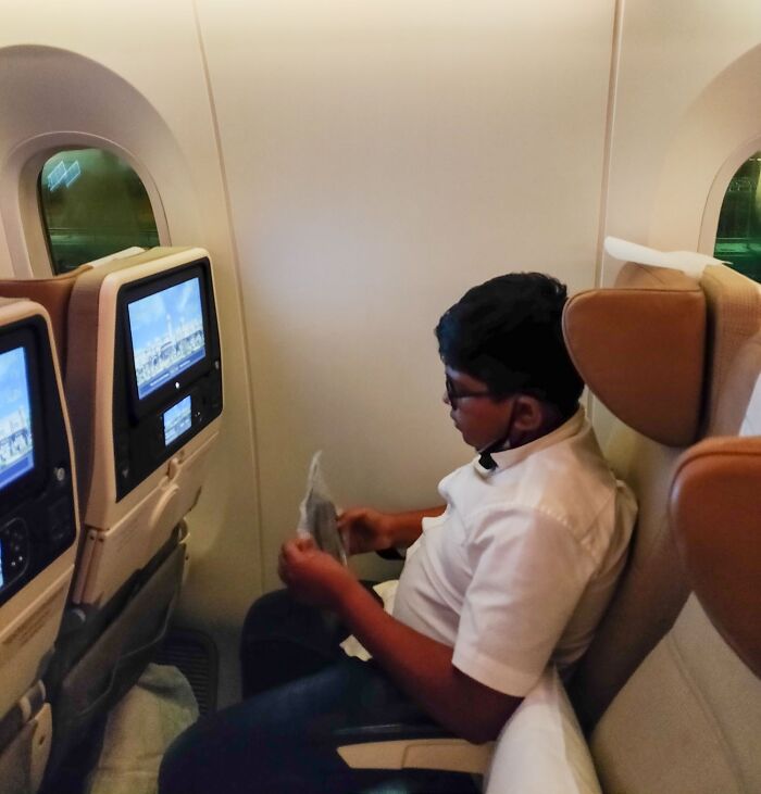 Niño en avión mostrando expresión de frustración en escena relacionada con padres y madres teniendo un día peor que el tuyo.