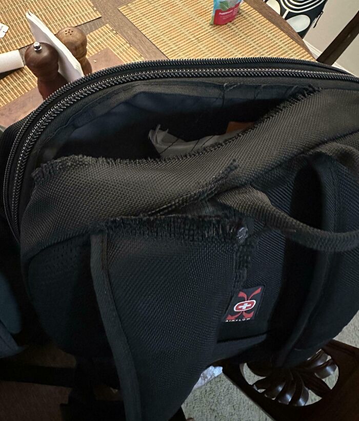 Mochila negra con desgaste visible en el asa, ejemplificando un día peor para padres y madres en situaciones cotidianas.