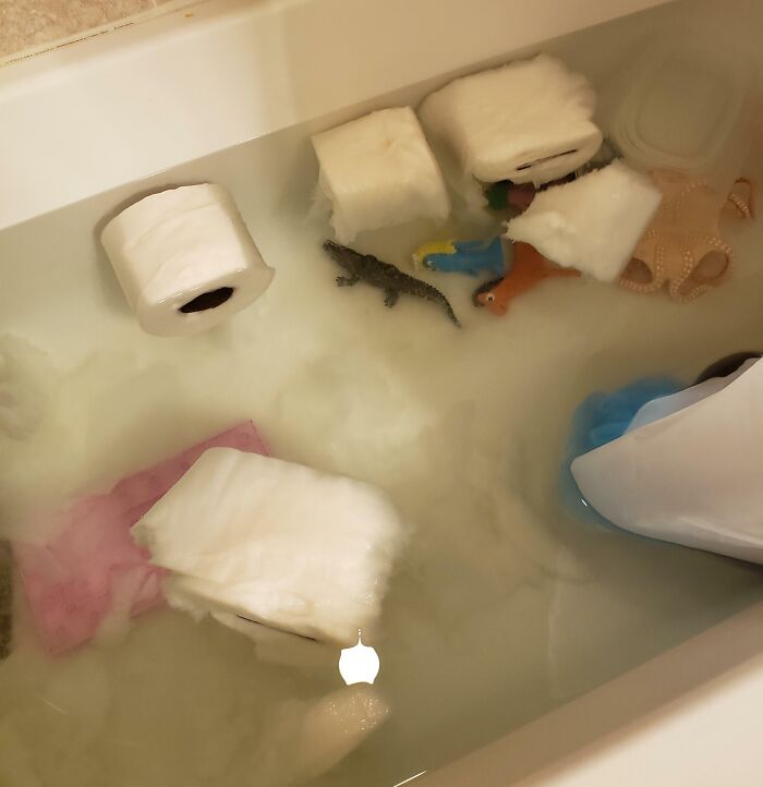 Padres y madres enfrentan un día peor con juguetes y papel higiénico flotando en agua dentro de una bañera.