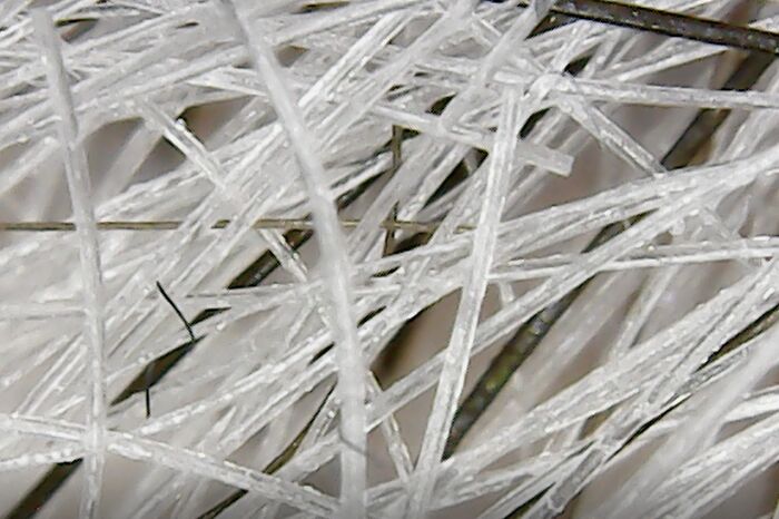Microscopic image showing a detailed close-up of tangled white and black fibers revealing texture and structure.