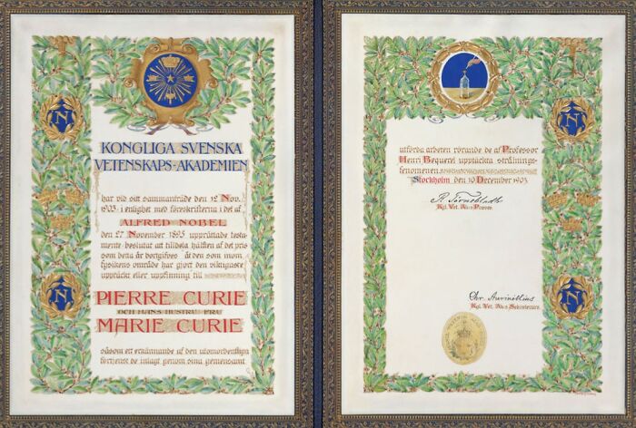 Decorative framed certificate featuring Pierre Curie and Marie Curie's Nobel Prize with ornate laurel border and gold details.