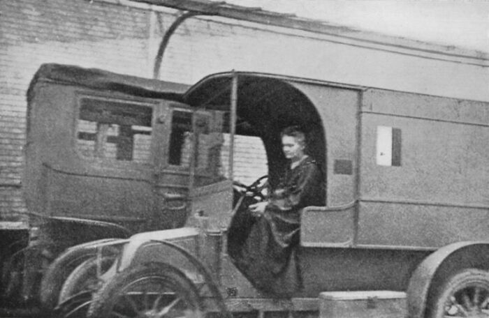Marie Curie seated in an early 20th-century vehicle, illustrating lesser-known facts about Marie Curie’s life and work.