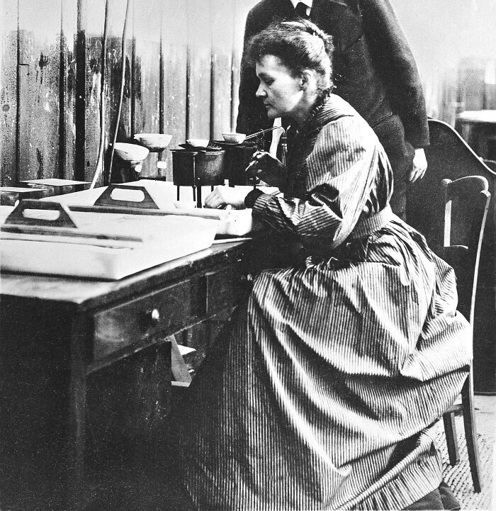 Marie Curie in a vintage laboratory setting, focused on scientific experiments and early research equipment.