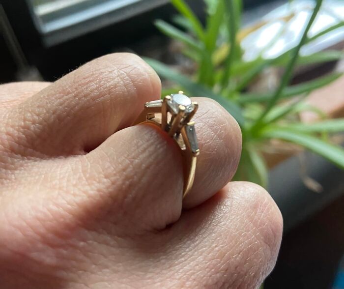 Close-up of a hand holding a gold ring with diamonds, an unexpected thing found in hidden places in homes.