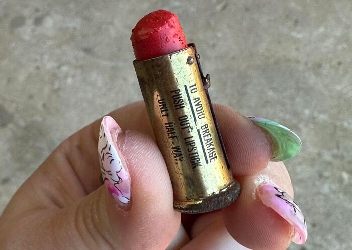 Hand holding a vintage lipstick case found hidden in walls, showcasing unexpected things found in walls and hidden places.