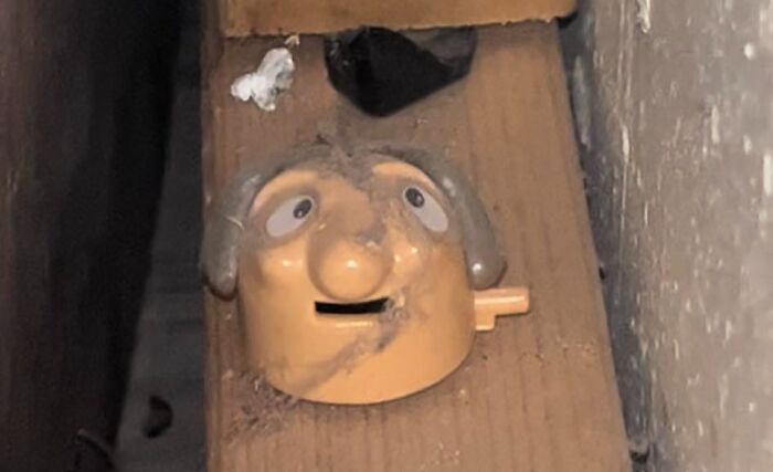 Dusty old toy head found hidden inside a wall, one of the unexpected things discovered in homes and other hidden places.