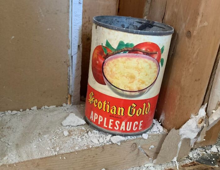 Vintage canned applesauce hidden inside a wall cavity, one of the unexpected things found in hidden places in homes.
