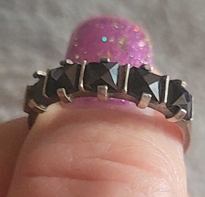 Close-up of a ring with black stones found unexpectedly in walls and other hidden places in people’s homes.