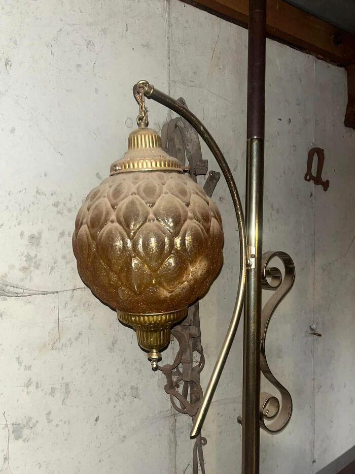 Vintage decorative hanging lamp with ornate design discovered among unexpected things found in walls and hidden places in homes.