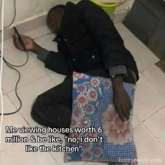 Person lying on the floor holding a phone with meme text about viewing expensive houses, illustrating relatable chaos for women today.