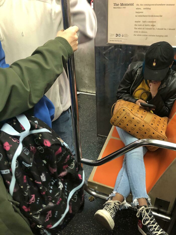 Public transport passenger taking up extra space by placing a large bag on the subway seat, ignoring other commuters.