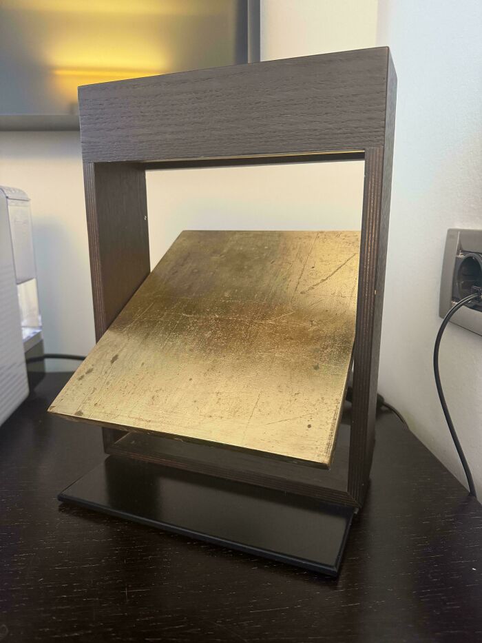 Wooden and metal object with an angled brass plate displayed on a desk, featured in mystery objects recognition online group.