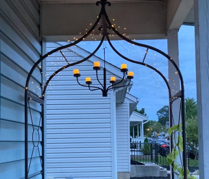 Outdoor space lit with warm hanging chandelier candles and string lights, enhancing usability and ambiance after dark.