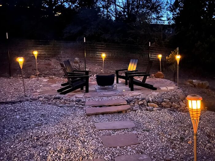Outdoor space illuminated with tiki torches and seating area enhancing usability after dark.