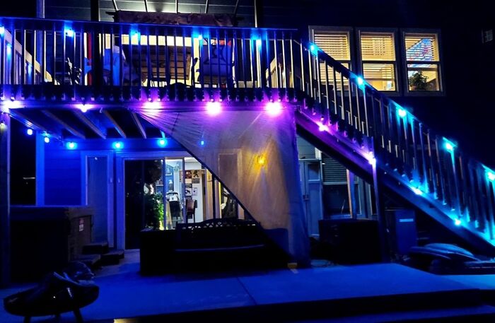 Outdoor space with colorful LED lights illuminating stairs and deck area for extended nighttime use.