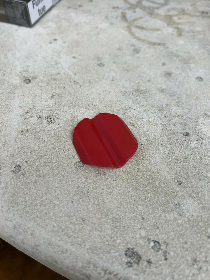 Red plastic mystery object with a central ridge, featured in an online group recognizing unknown mystery objects.