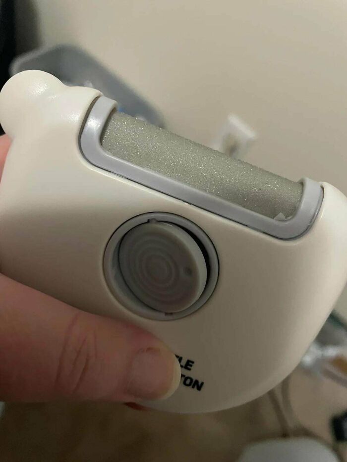 Hand holding a mystery object with a roller and central button, featured in an online group recognizing mystery objects.