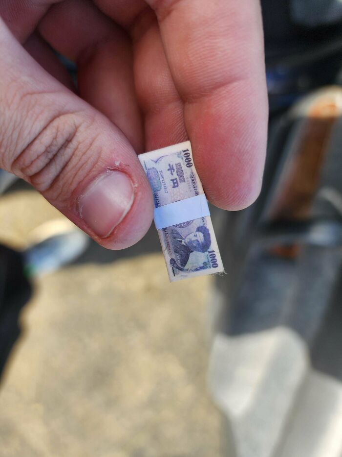 Close-up of a hand holding a tiny folded object resembling a banknote, one of many mystery objects recognized online.
