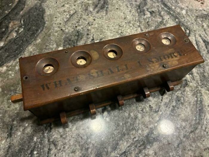 Wooden vintage mystery object with circular holes and hooks, part of an online group helping recognize mystery objects.