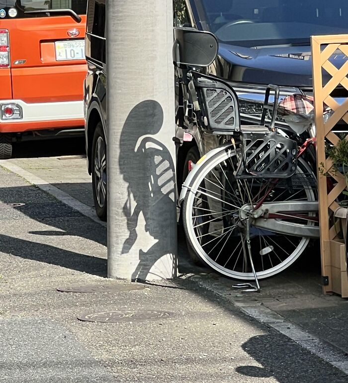 Bicycle shadow on a pole creates an interesting shape that requires a double take to realize what it really is.