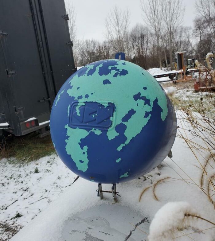 Painted globe-shaped object outdoors in snow, one of the interesting things that required a double take to realize.