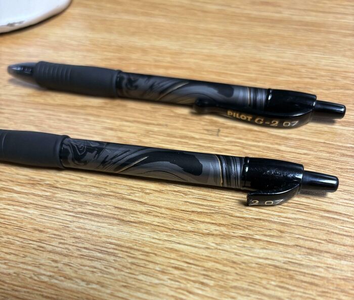 Two black Pilot G-2 pens on a wooden surface, one broken and damaged, illustrating people damaging things they borrowed.