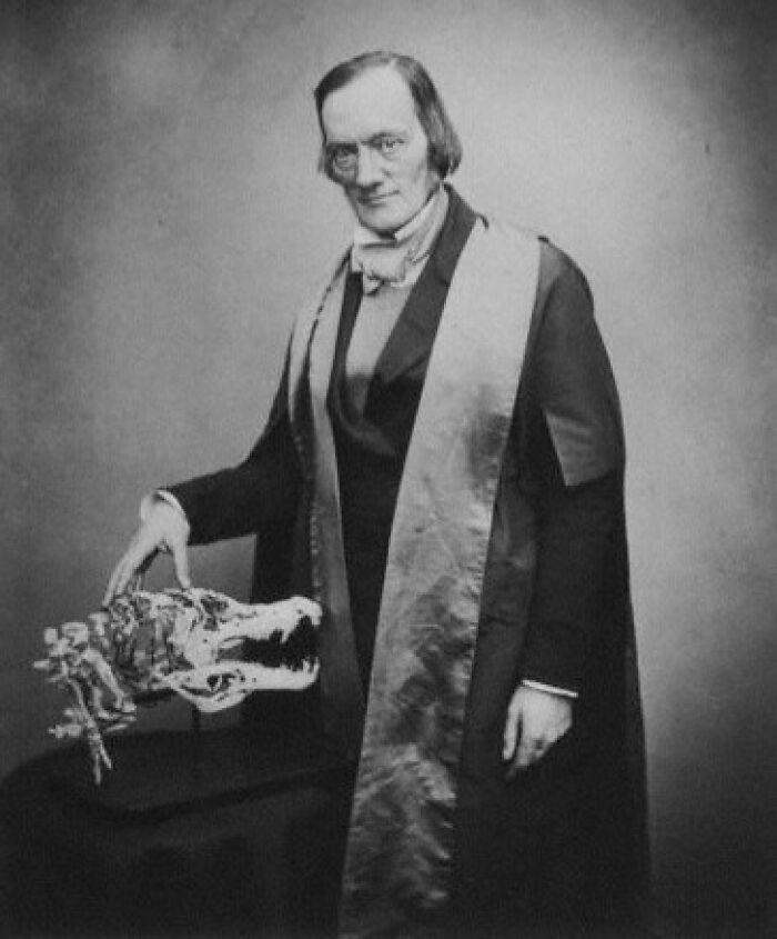 19th-century paleontologist in formal attire posing with a dinosaur skull skeleton, related to dinosaur facts discovery.