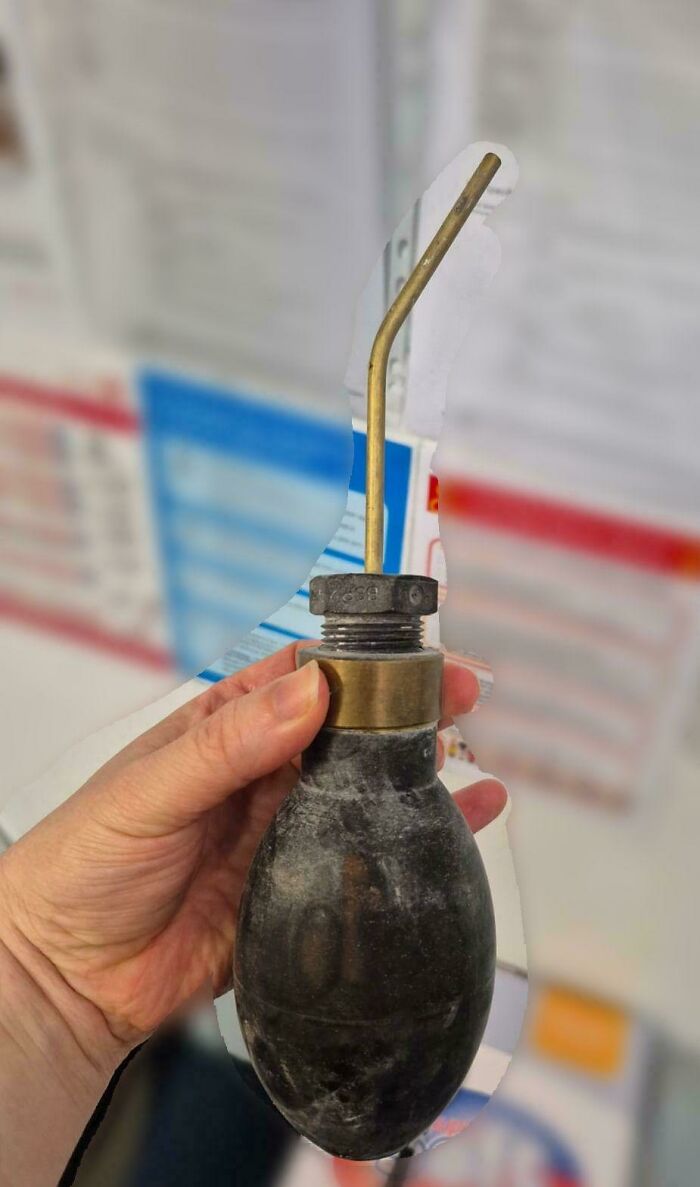 Hand holding a vintage mystery object with a bent metal tube, featured in an online group recognizing mystery objects.