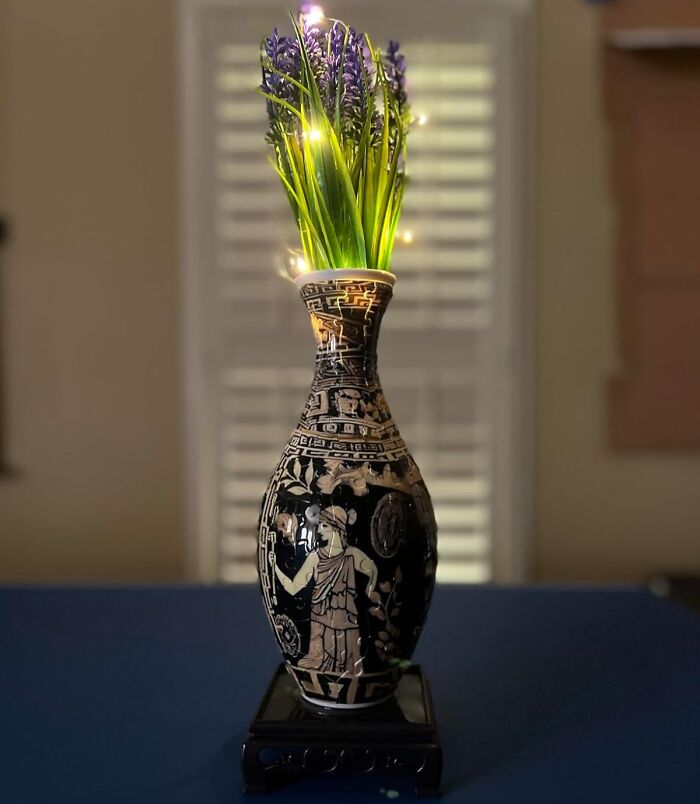 Decorative artistic vase with intricate ancient designs holding purple flowers, highlighting creative spirit and arty finds.