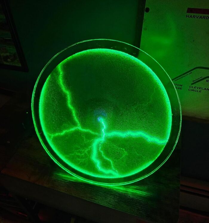 Glowing green circular electric art piece with lightning-like patterns, highlighting creative spirit and arty finds.
