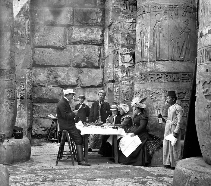 Victorian times tea gathering in ancient ruins with people in period dress, showcasing strange moments from Victorian era life.