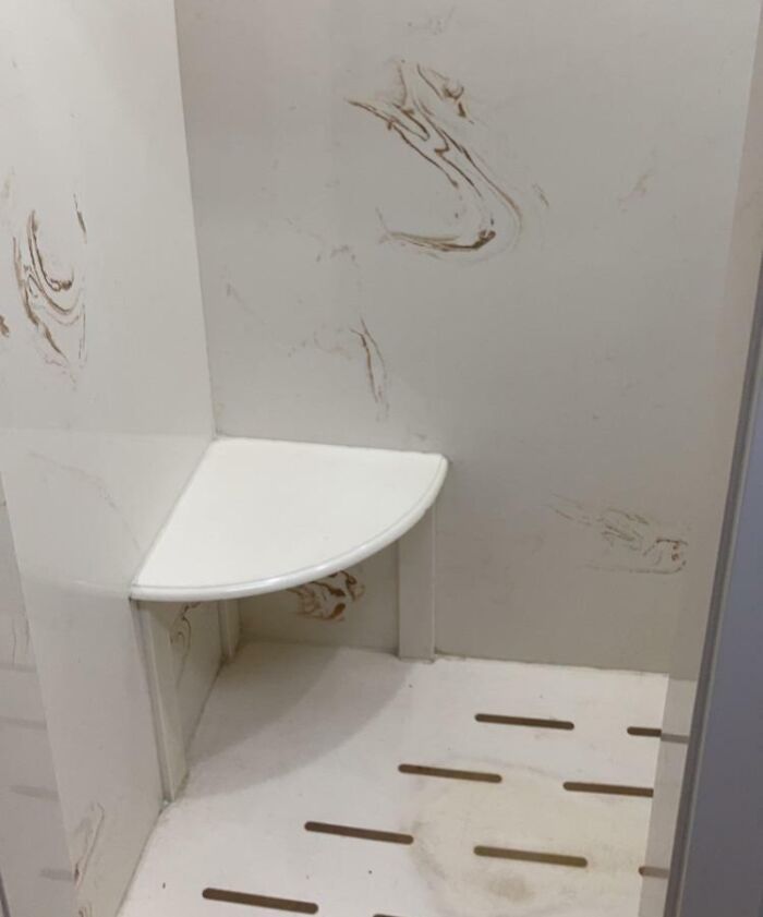 Small corner bench and floor slats in a gym shower area, illustrating annoying gym moments with inconvenient design.