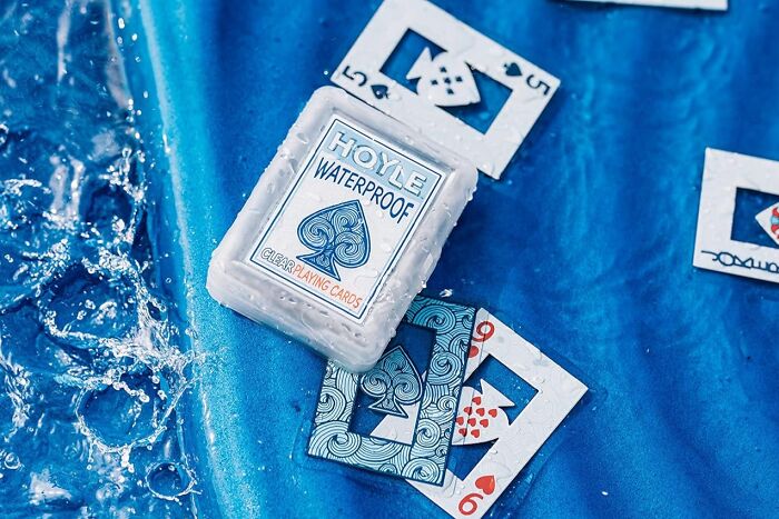 Waterproof playing cards on a wet blue surface as a must-have find to conquer sun, sand, and snack attacks at the beach.