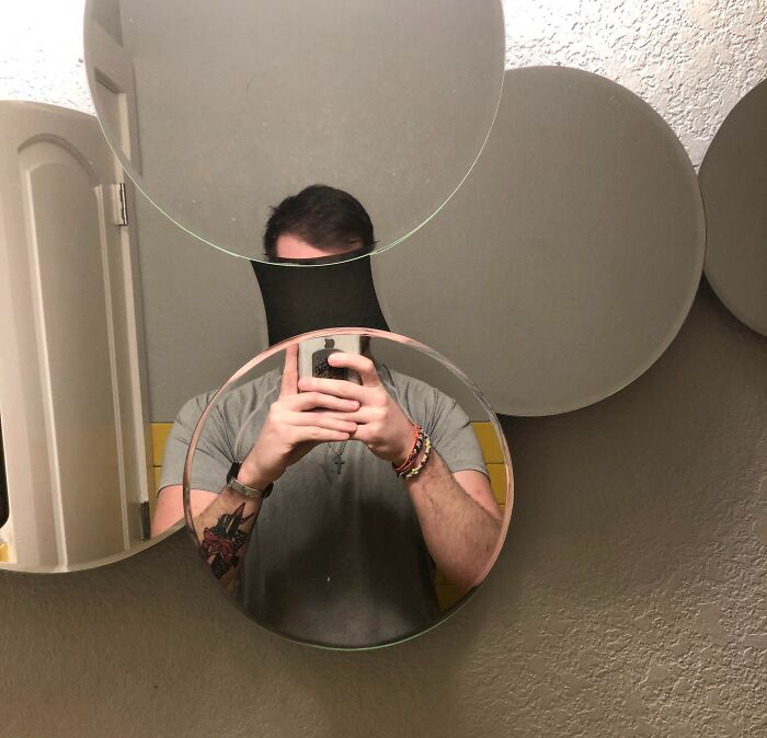 Man taking a selfie in a creative circular mirror arrangement, representing annoying gym moments and running alternatives.