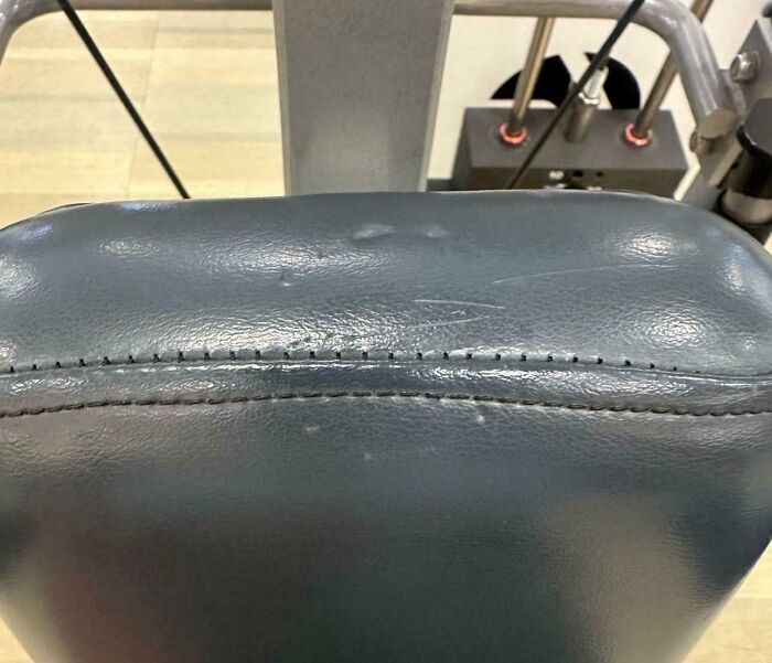 Close-up of worn gym equipment seat highlighting common annoying gym moments affecting workout comfort.