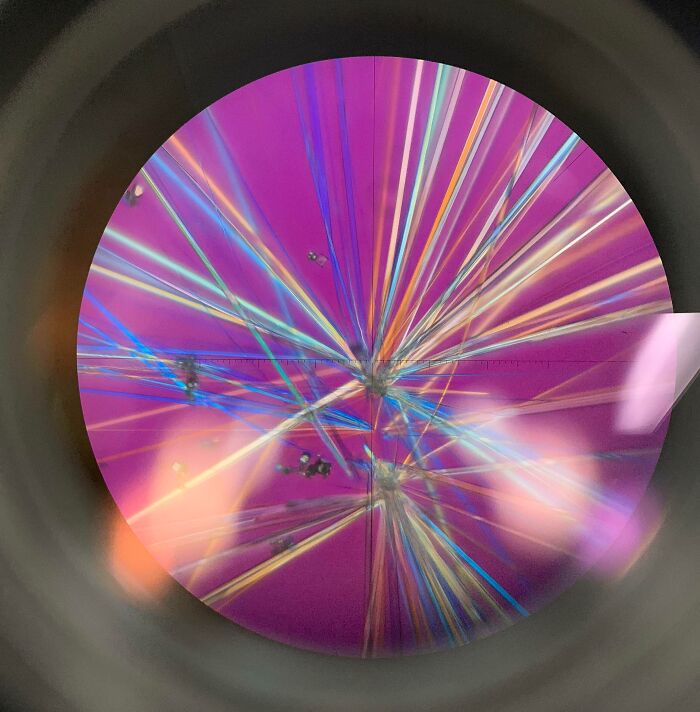 Colorful microscopic image showing crystalline structures with vibrant lines and patterns under high magnification.